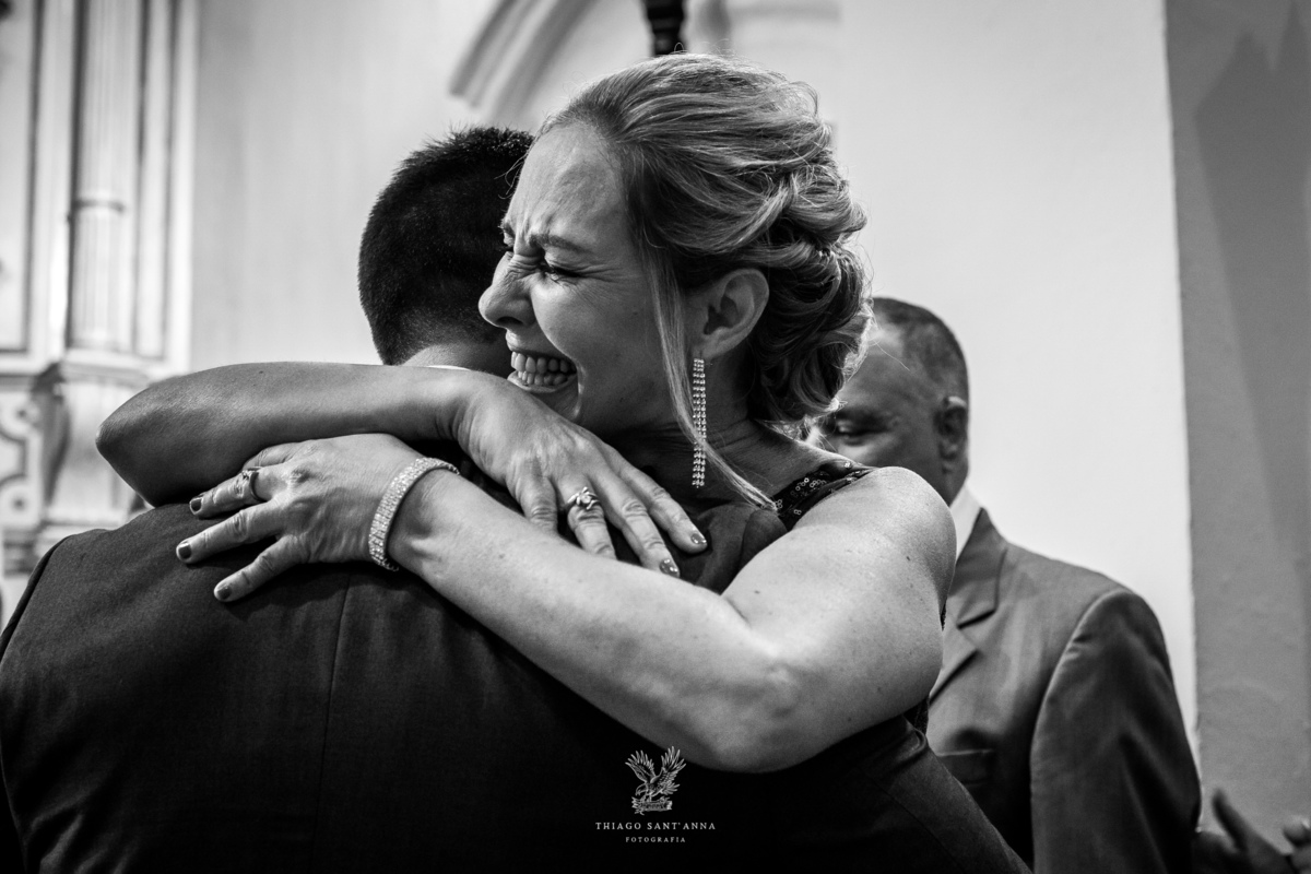 Mãe do noivo o abraça emocionada preto e branco