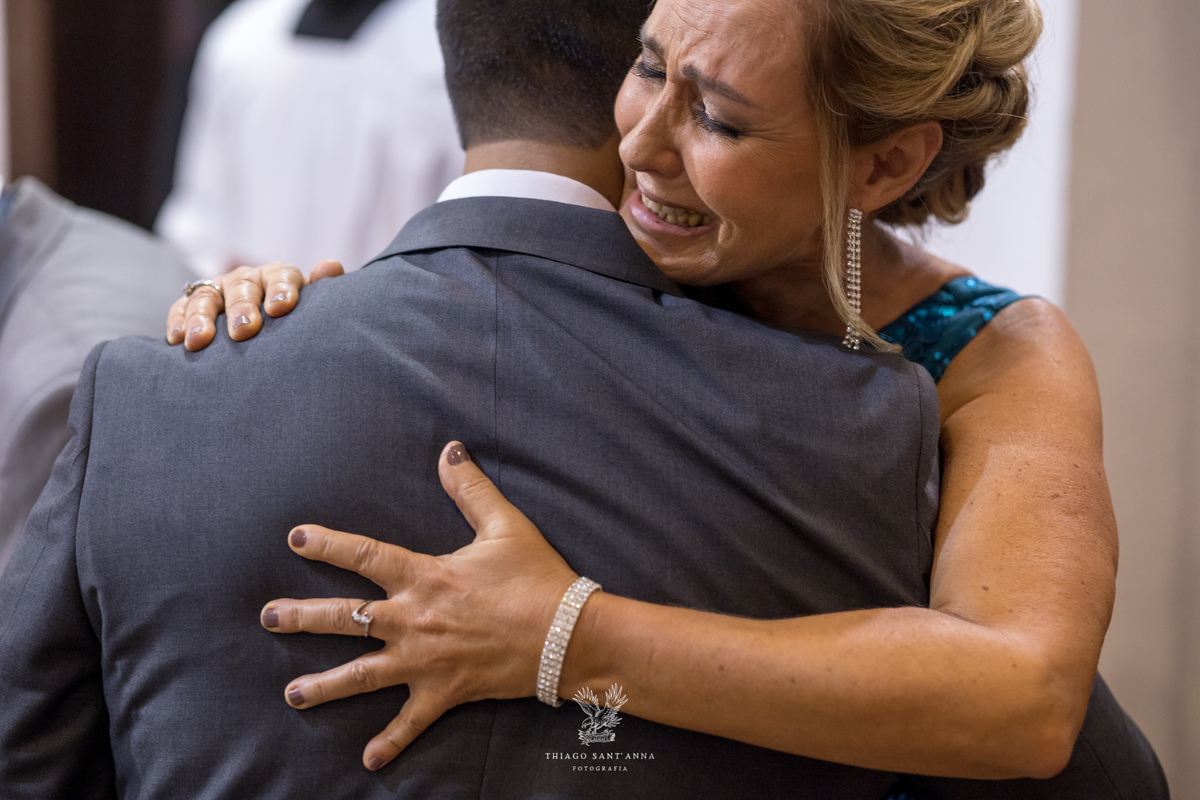Mãe do noivo o abraça emocionada