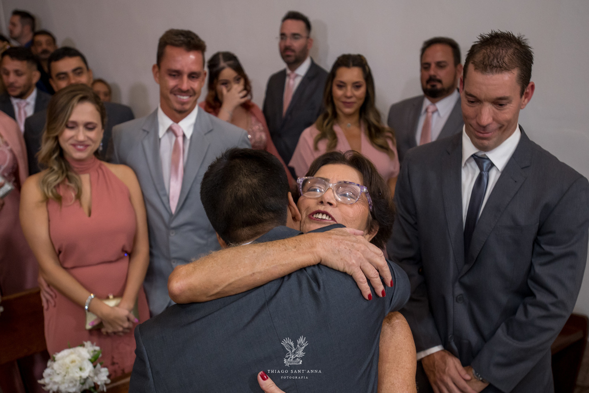 Mãe da noiva abraça abraça o noivo emocionada