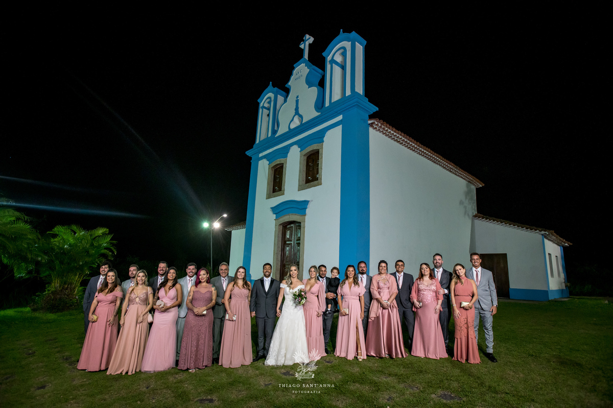 Padrinhos madrinhas e noivos posam frente a igreja