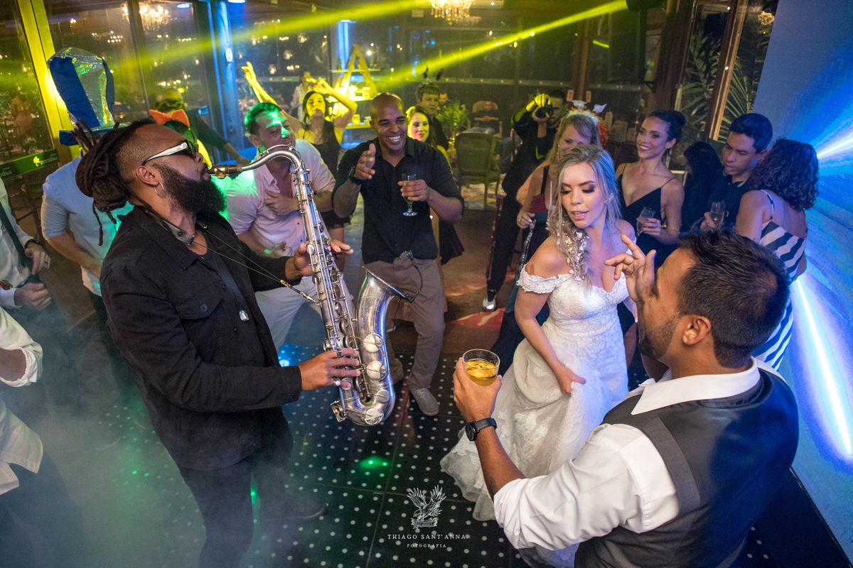 Noivos convidados e músico na pista de dança