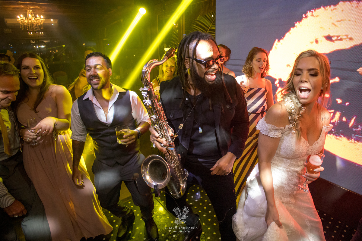 Noivos convidados e músico na pista de dança
