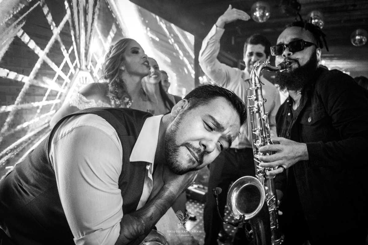 Noivos convidados e músico na pista de dança