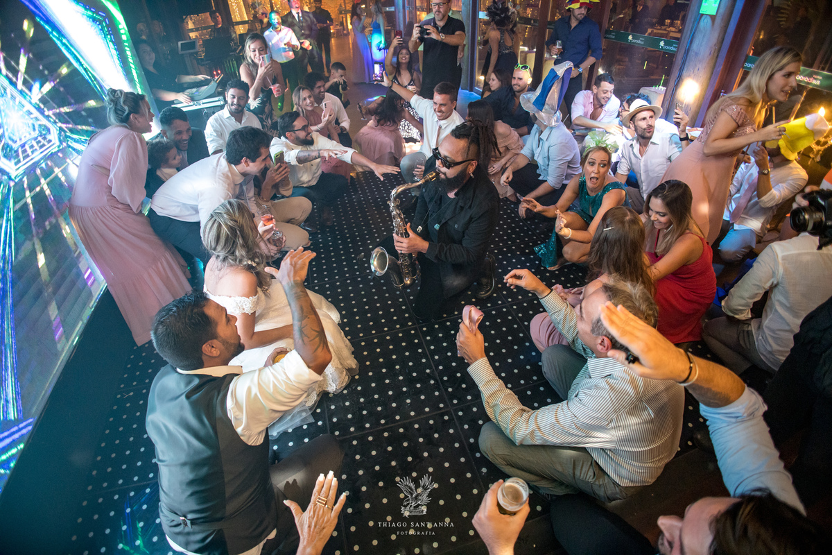 Noivos convidados e músico na pista de dança