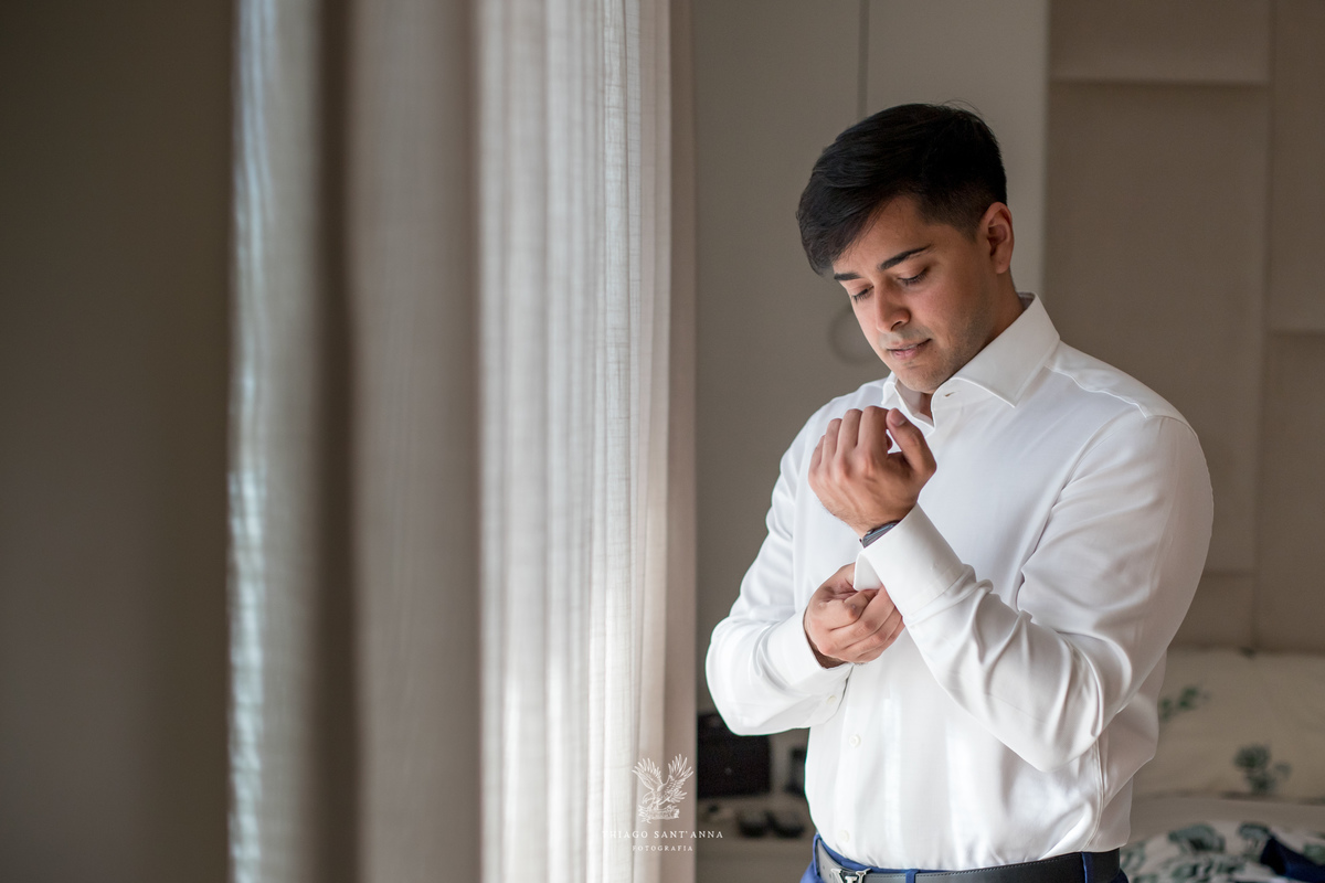 Making of do noivo calça azul camisa branca abotoando