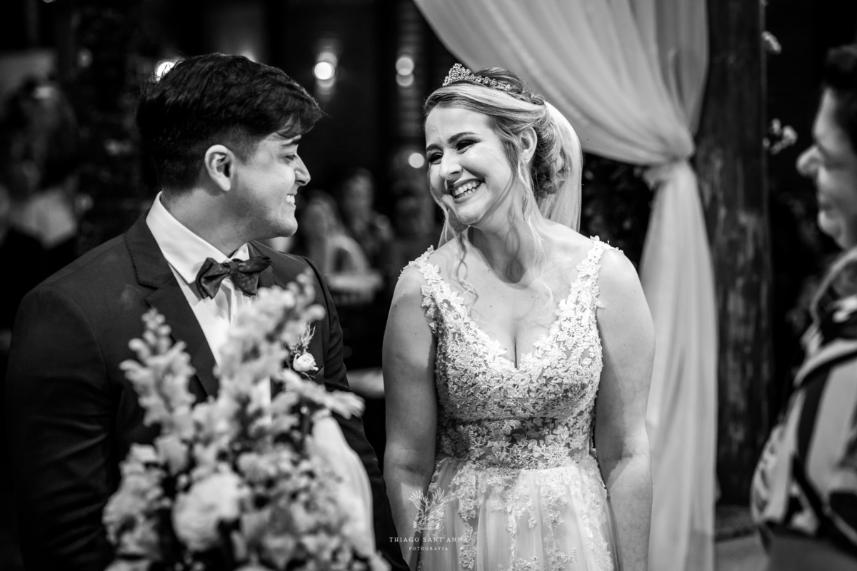 Noivos sorrindo no altar preto e branco