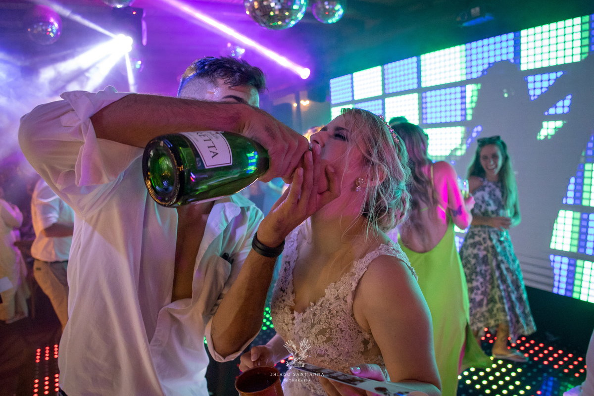 noivo coloca bebida na boca da noiva