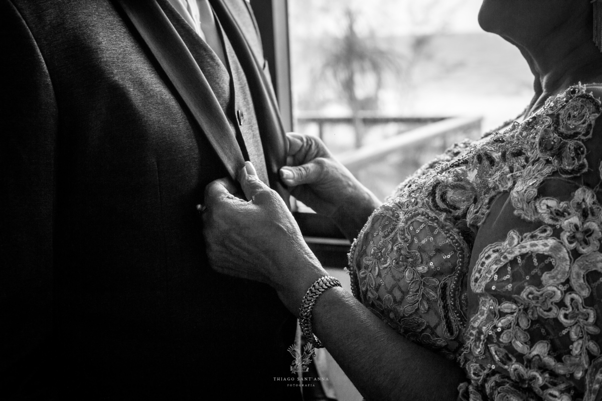 Making of do noivo mãe ajusta roupa preto e branco