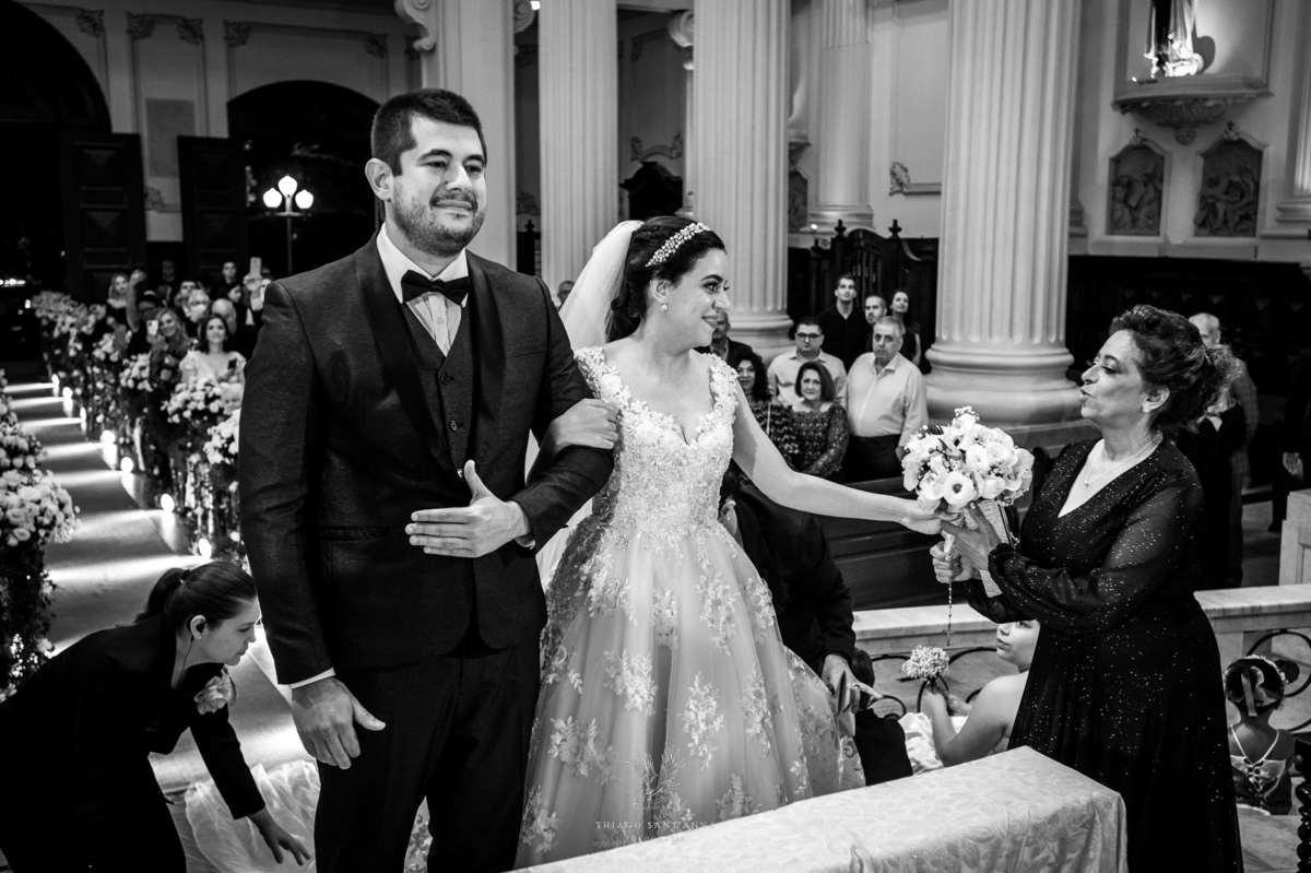 Noivos no altar noiva entrega o buquê preto e branco