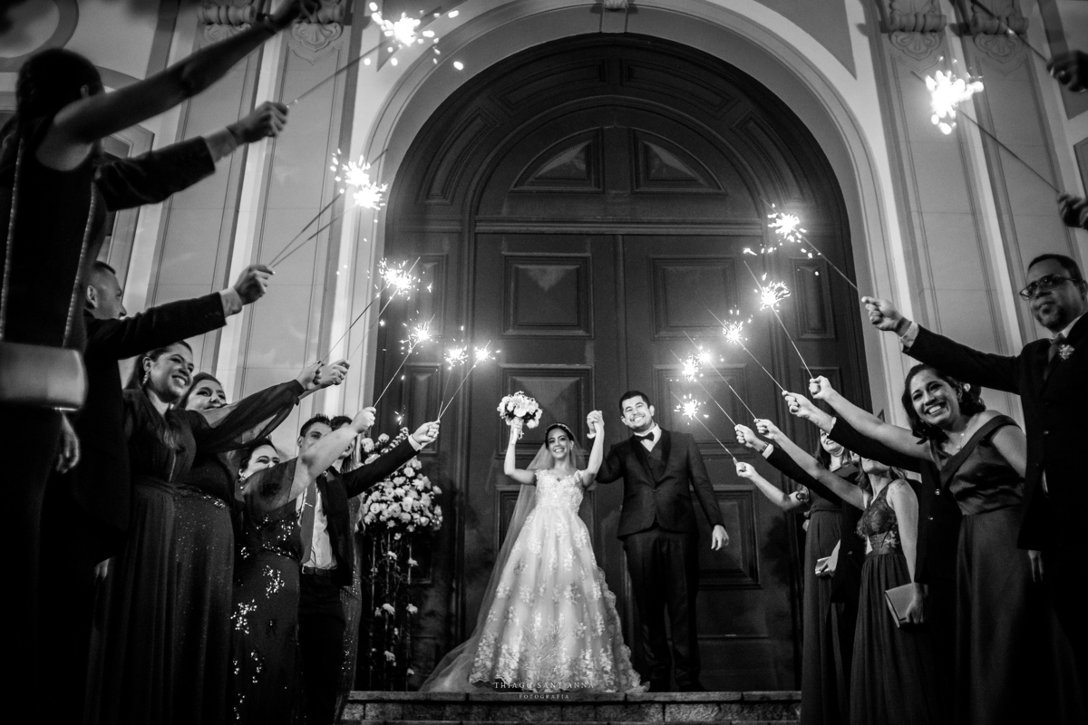 Saída dos noivos com sparkles na porta da igreja preto e branco
