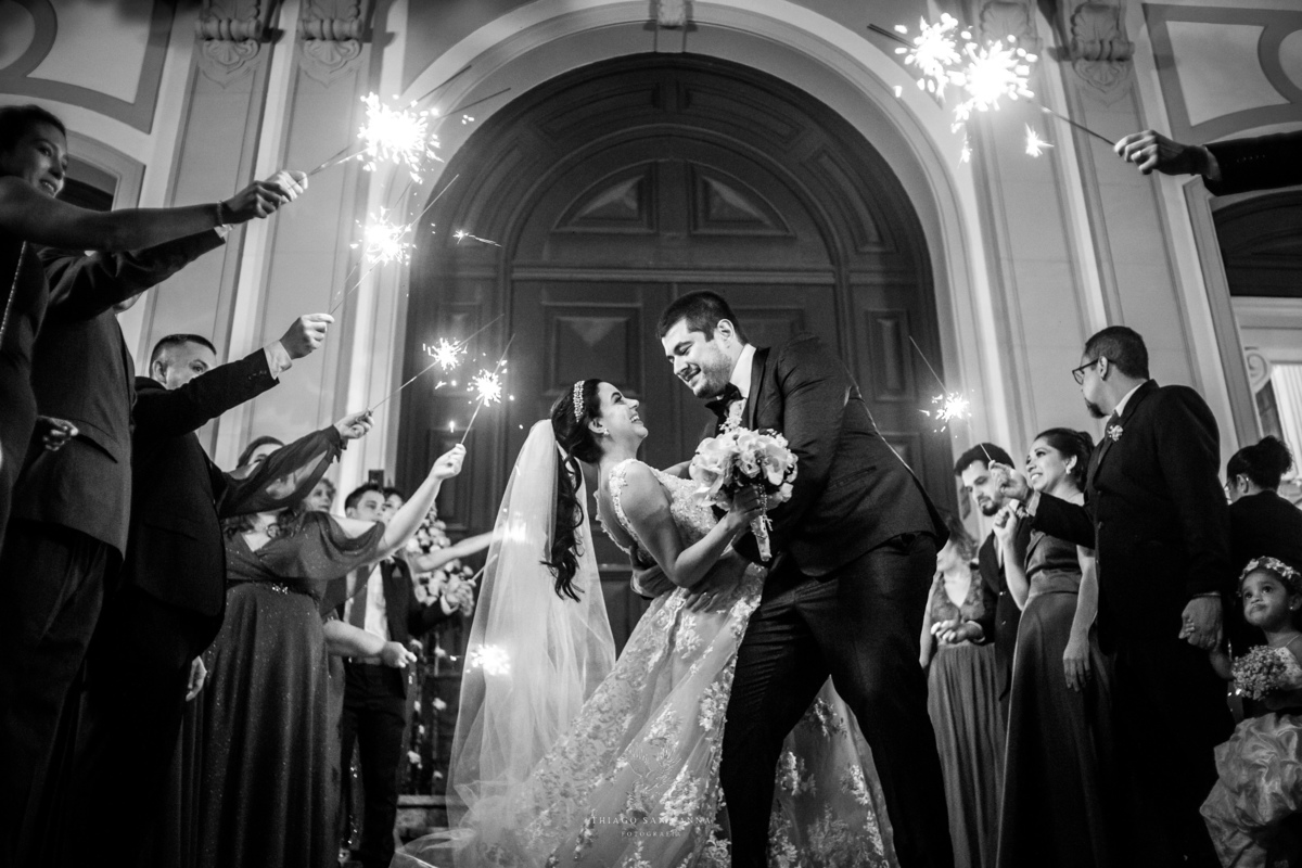 Saída dos noivos com sparkles na porta da igreja preto e branco