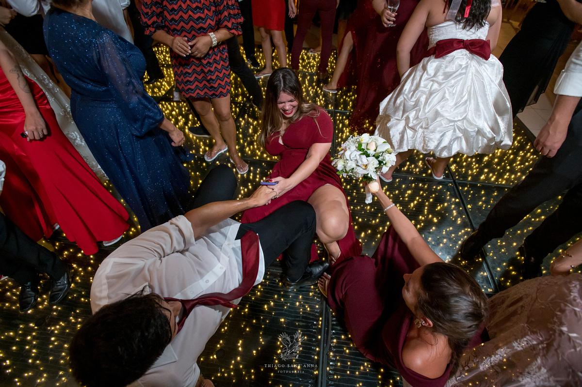 Noivos dançam na pista com madrinhas padrinhos e convidados