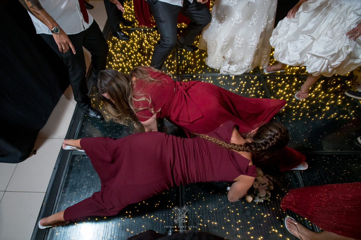 Noivos dançam na pista com madrinhas padrinhos e convidados