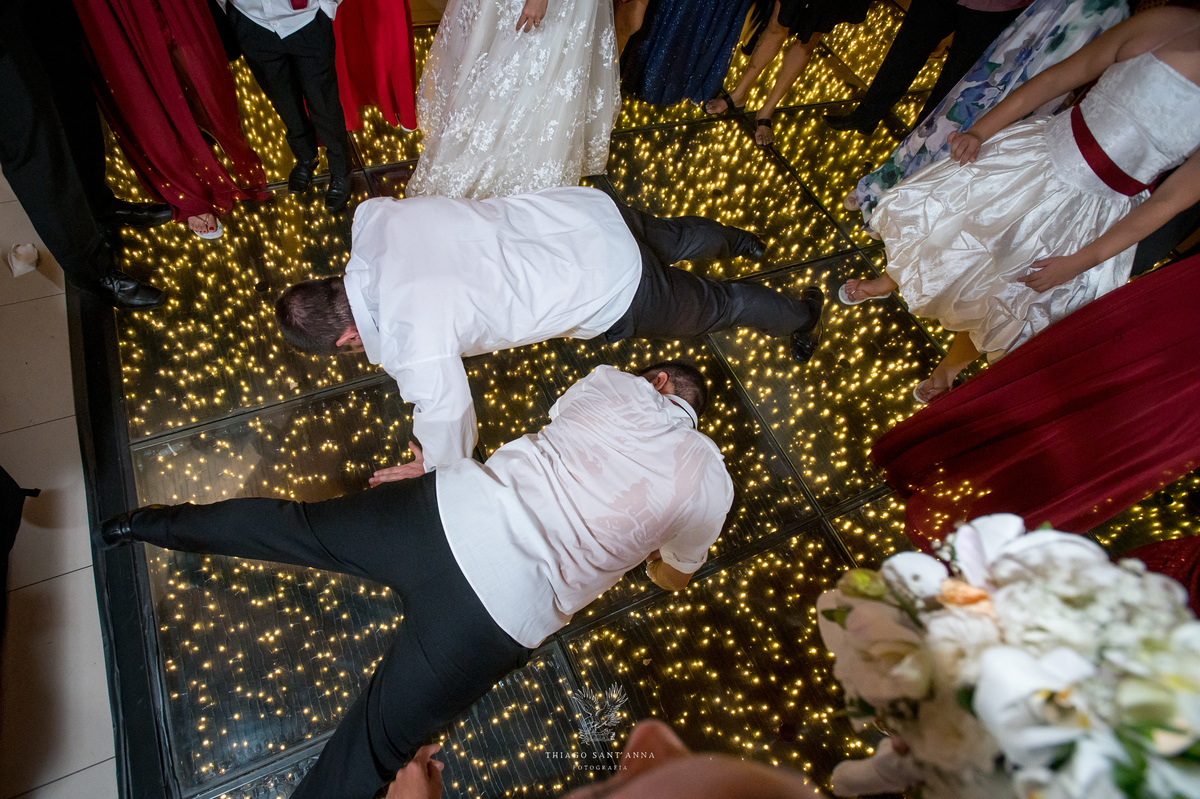 Noivos dançam na pista com madrinhas padrinhos e convidados