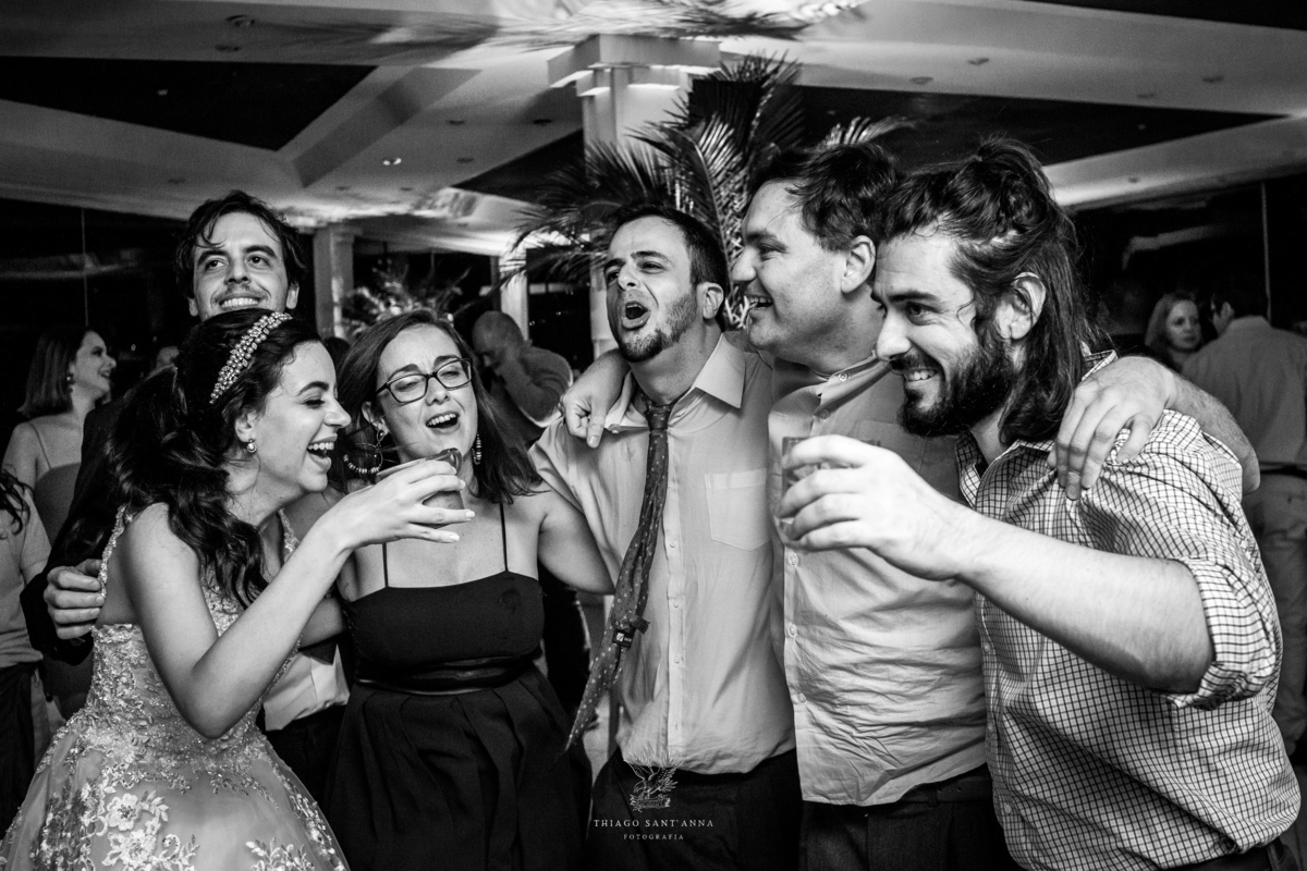 Noivos dançam na pista com madrinhas padrinhos e convidados