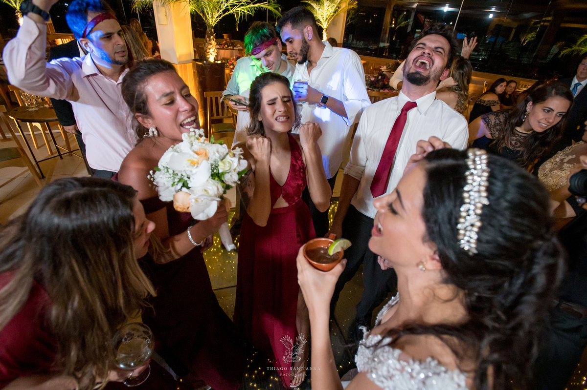 Noivos dançam na pista com madrinhas padrinhos e convidados