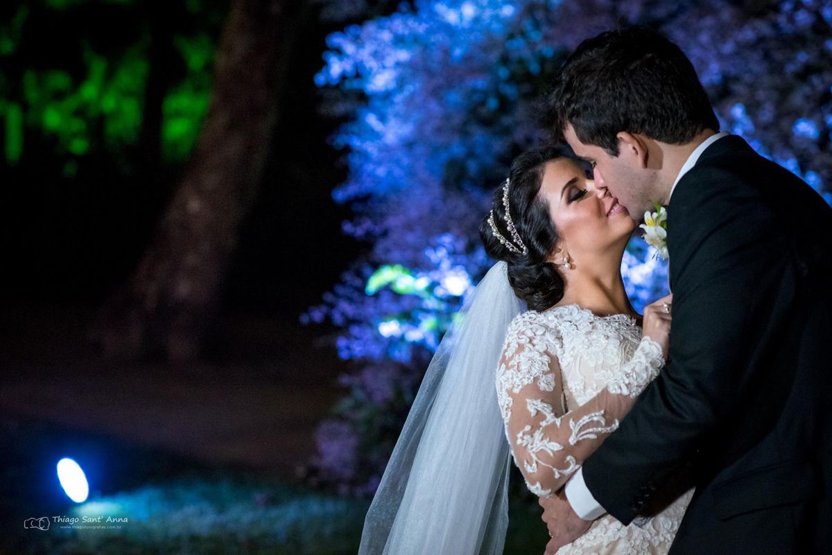 beijo dos noivos ambiente externo vegetação gramado árvore luz azul