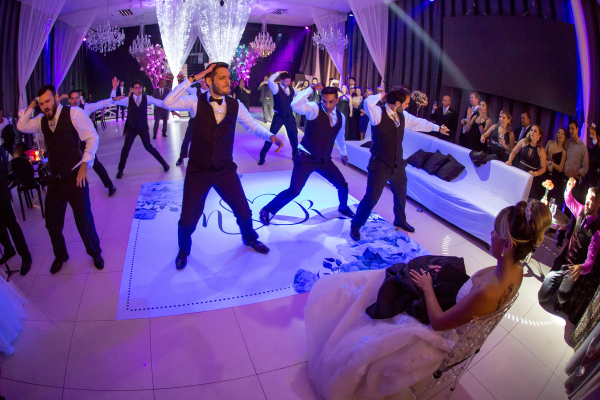 dança do noivo e padrinhos noiva sentada observa 