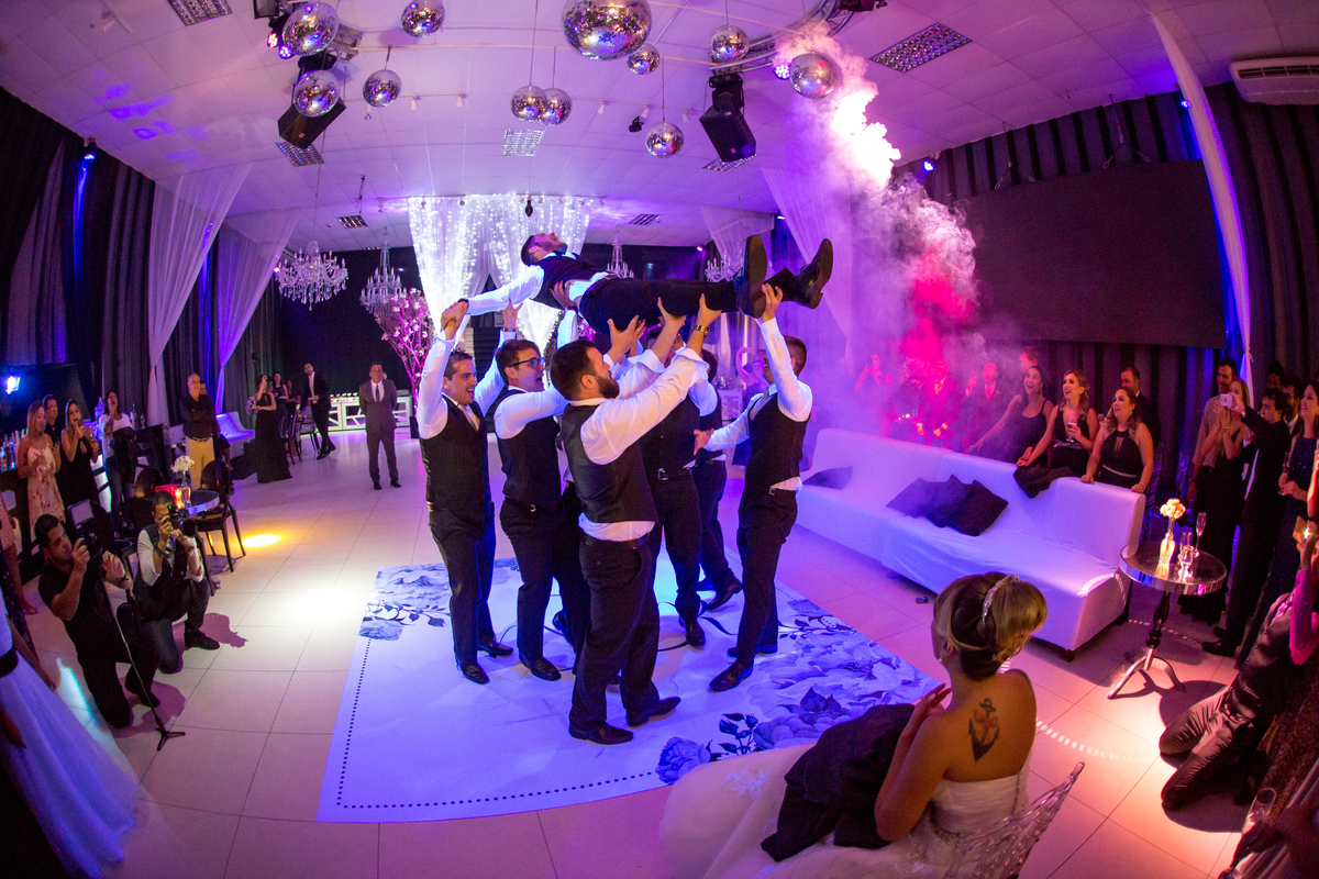 padrinhos levantam noivo no ar em dança para noiva