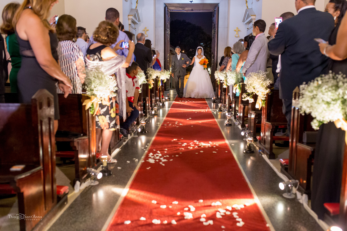 entrada da noiva com seu pai igreja católica tapete vermelho convidados observam