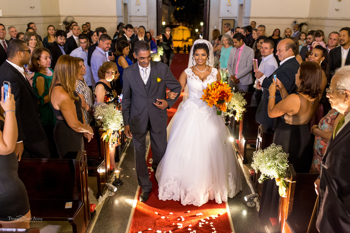 entrada da noiva com seu pai igreja católica tapete vermelho convidados observam