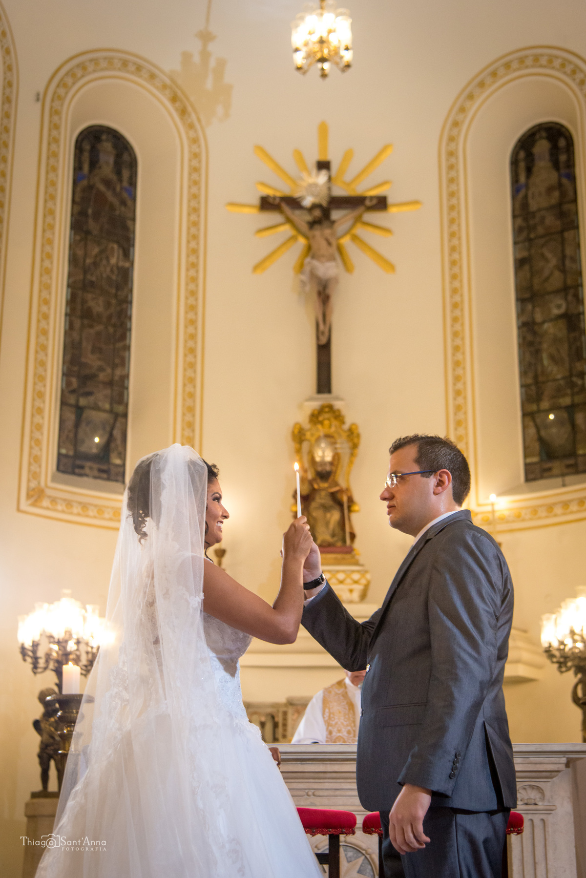 noivos no altar seguram vela noiva sorri 