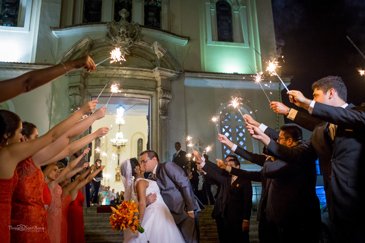 saída beijo dos noivos padrinhos estendem bastões luminosos