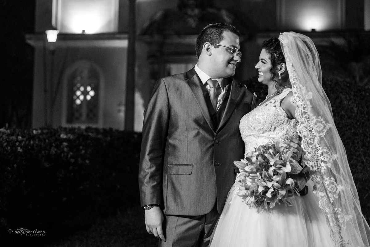 noivos posam frente a igreja preto e branco
