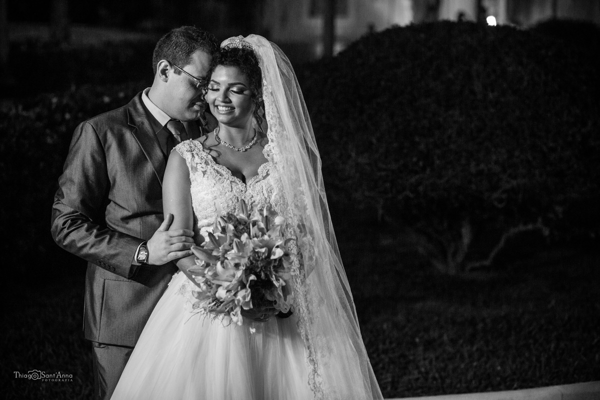 noivos posam frente a igreja preto e branco