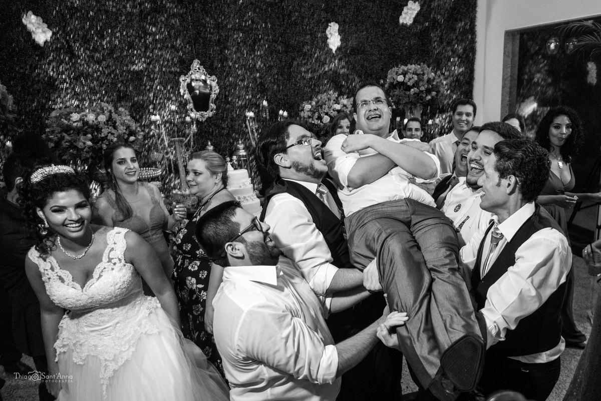 padrinhos levantam noivo nos braços preto e branco