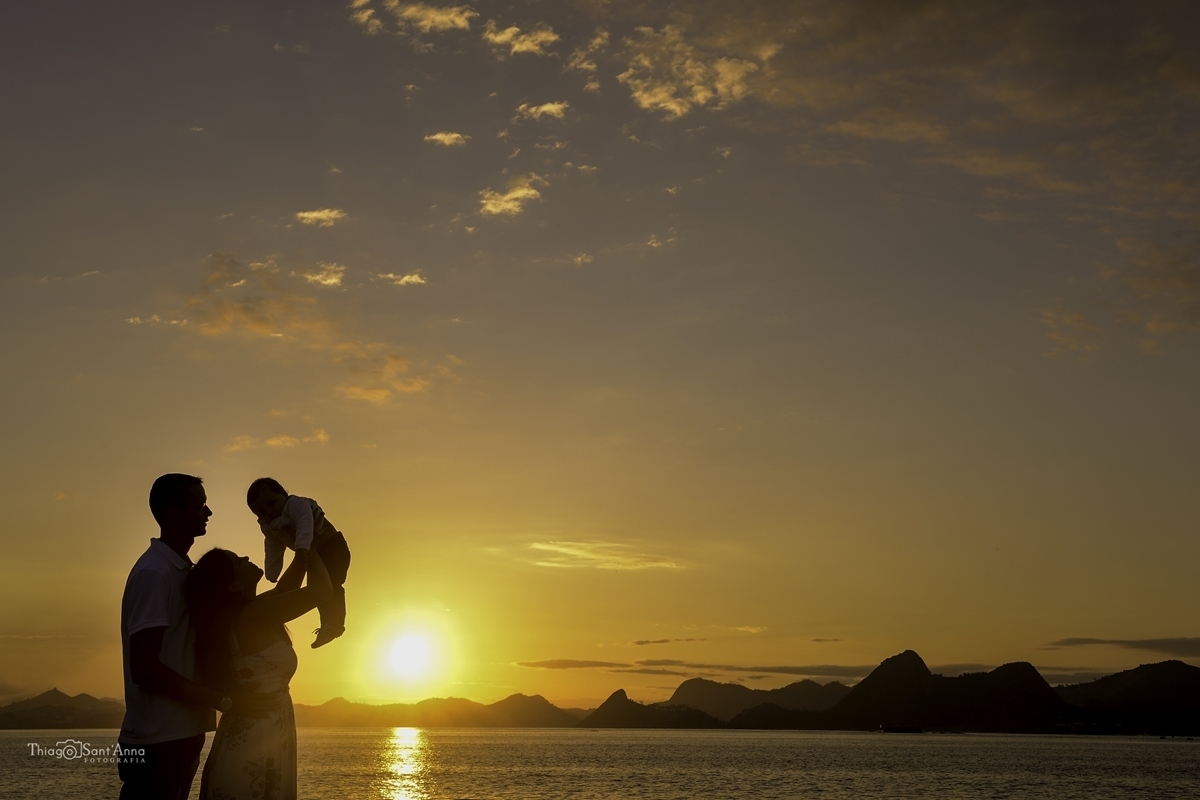 casal com seu bebê vendo o horizonte do amanhecer