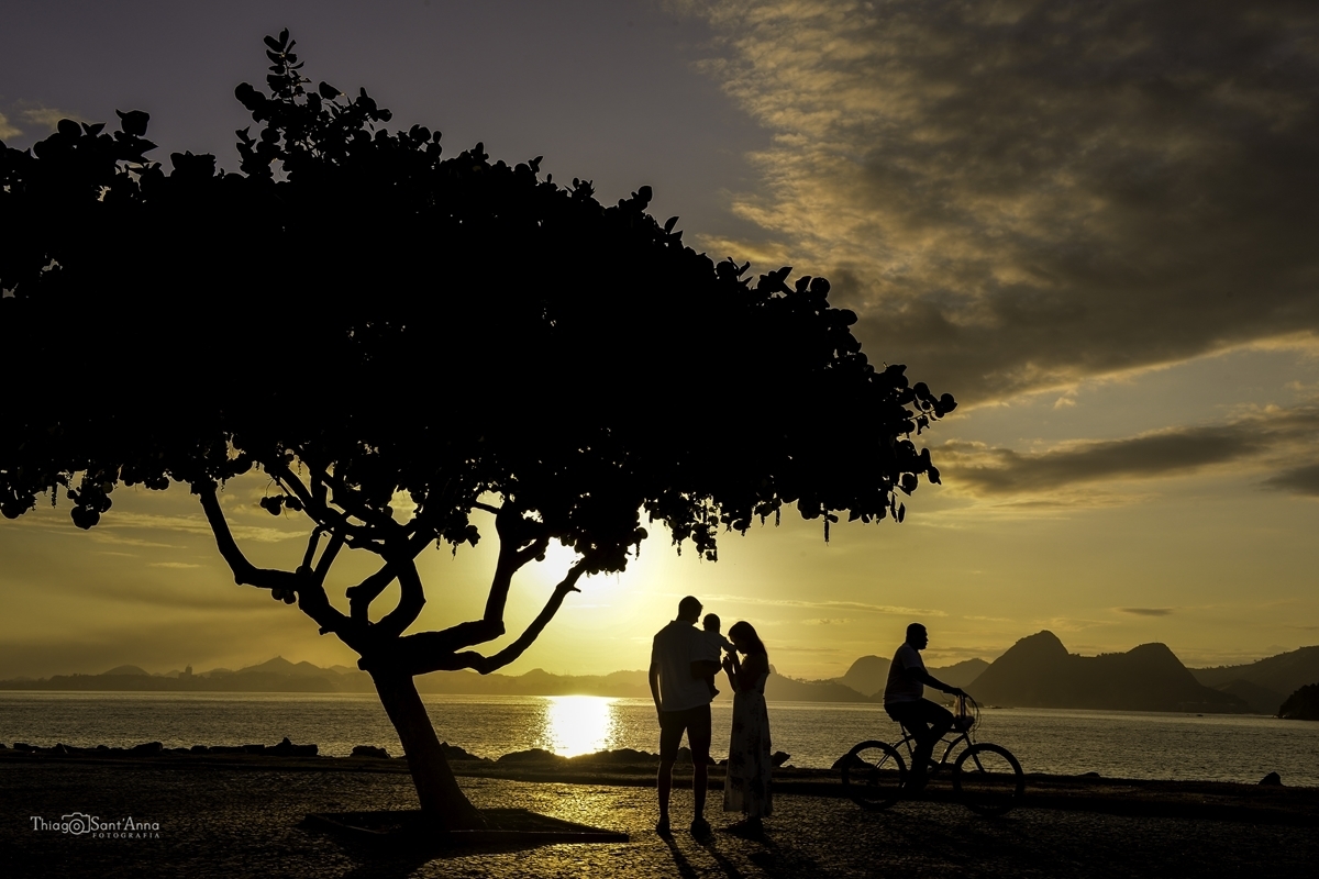 casal com seu bebê vendo o horizonte do amanhecer e bicicleta na ciclovia