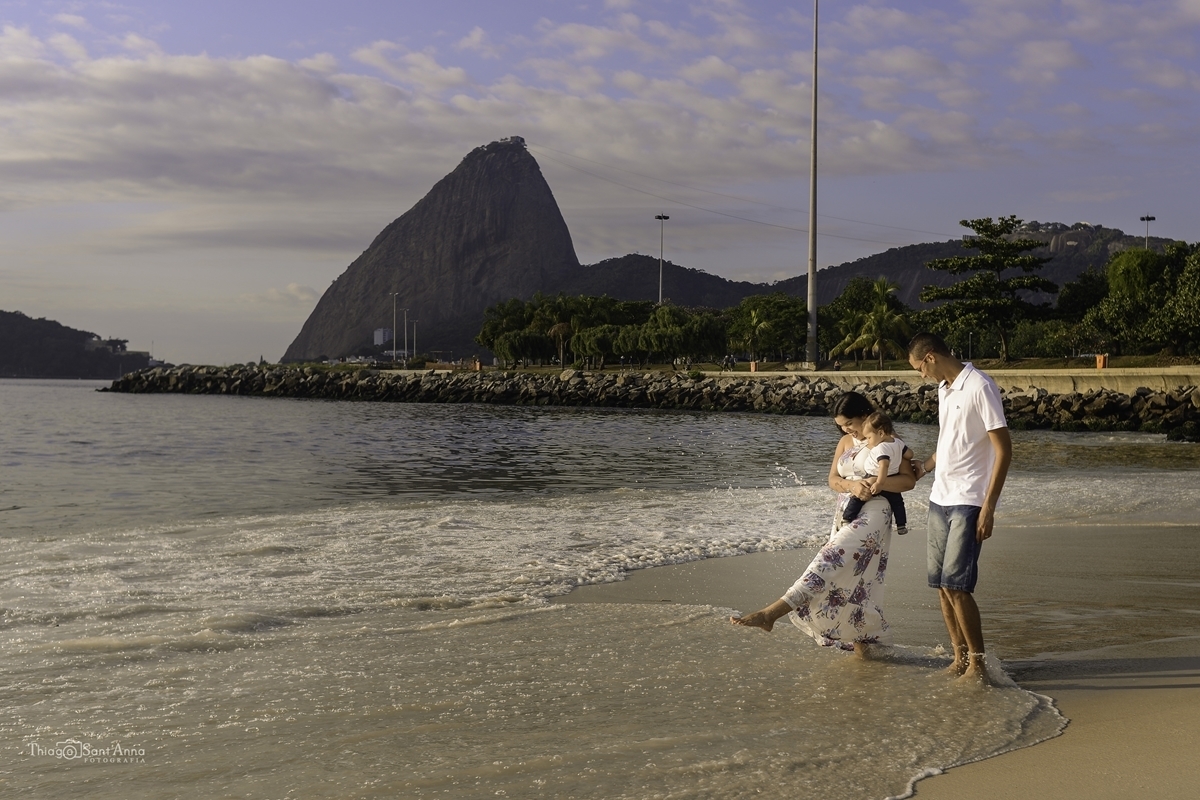 família caminhando com os pés na água na beira da praia do rio de janeiro