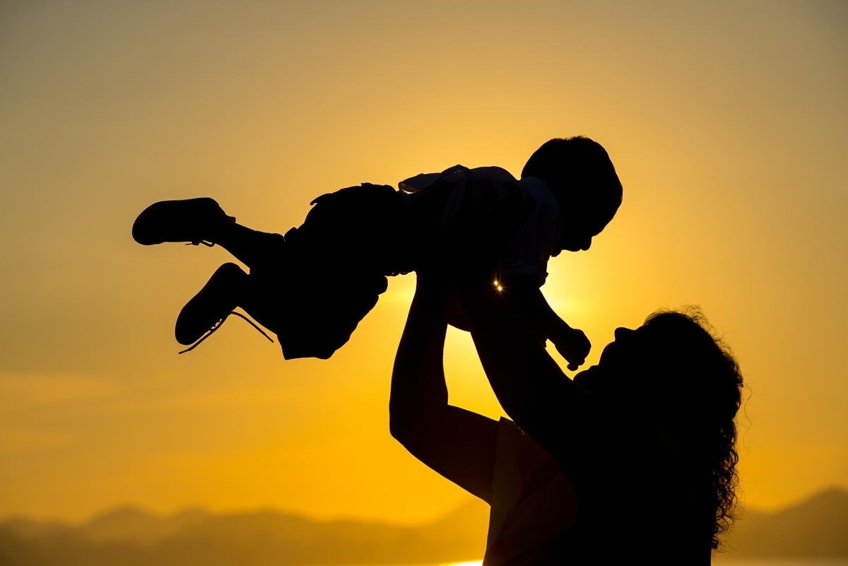 Mãe e filho contra luz do sol