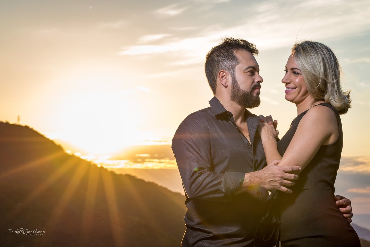 casal se olhando frente ao horizonte com a presença do sol