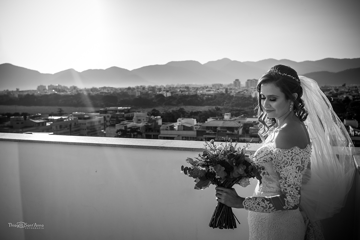 noiva olhando para o buquê com vista da cidade Rio de Janeiro