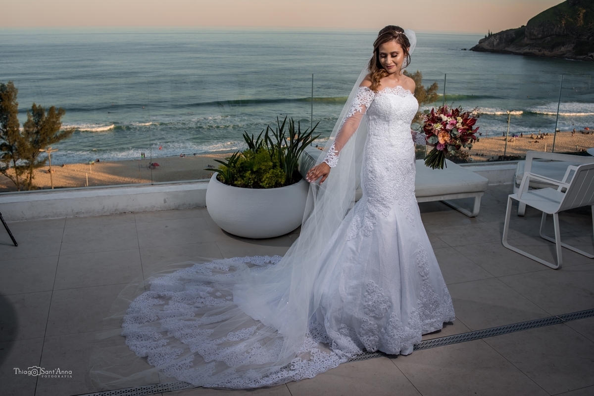 noiva vista de costas na varanda do hotel com orla da praia do recreio ao fundo antes do casamento no Rio de Janeiro