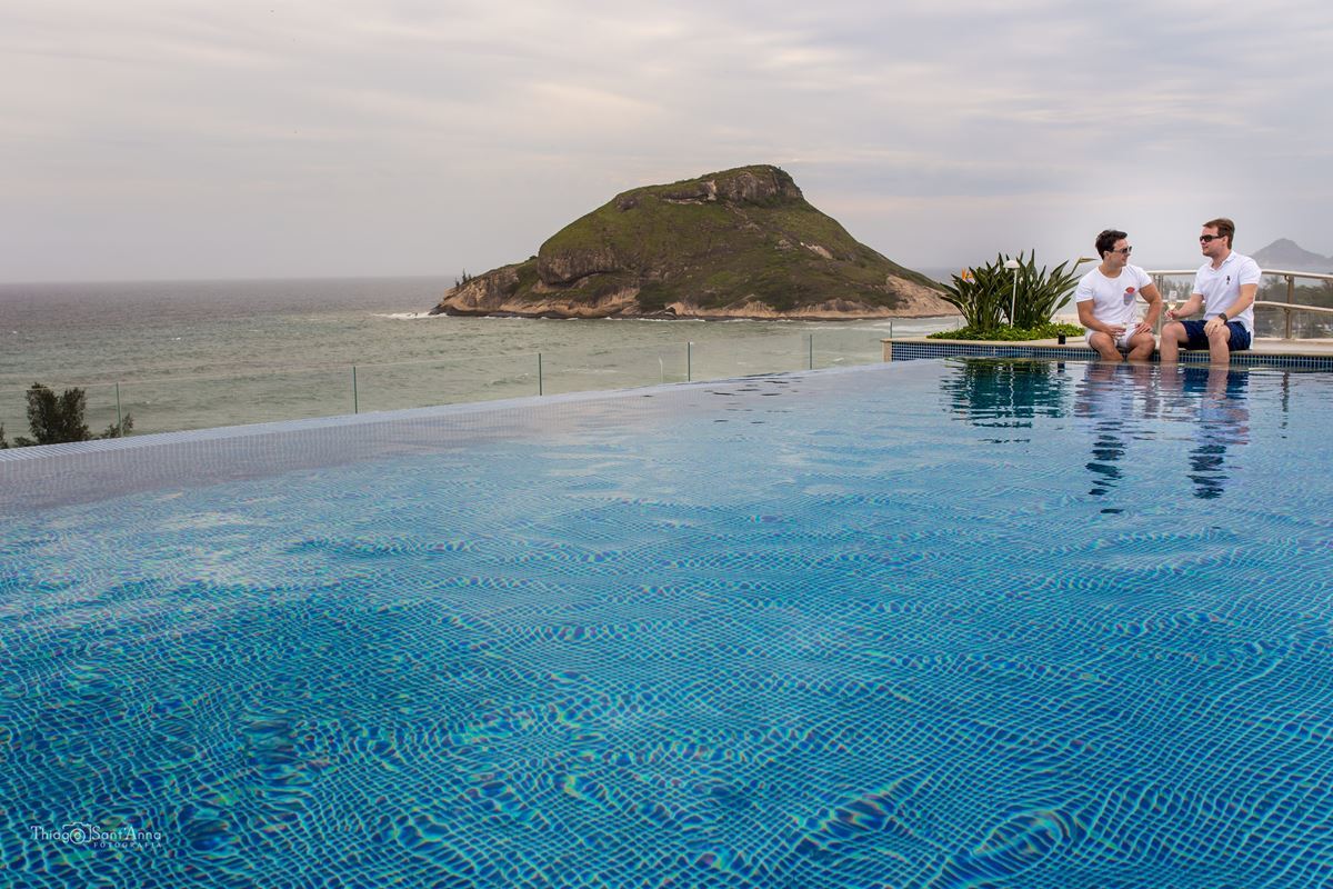noivos conversam sentados a beira da piscina paisagem mar