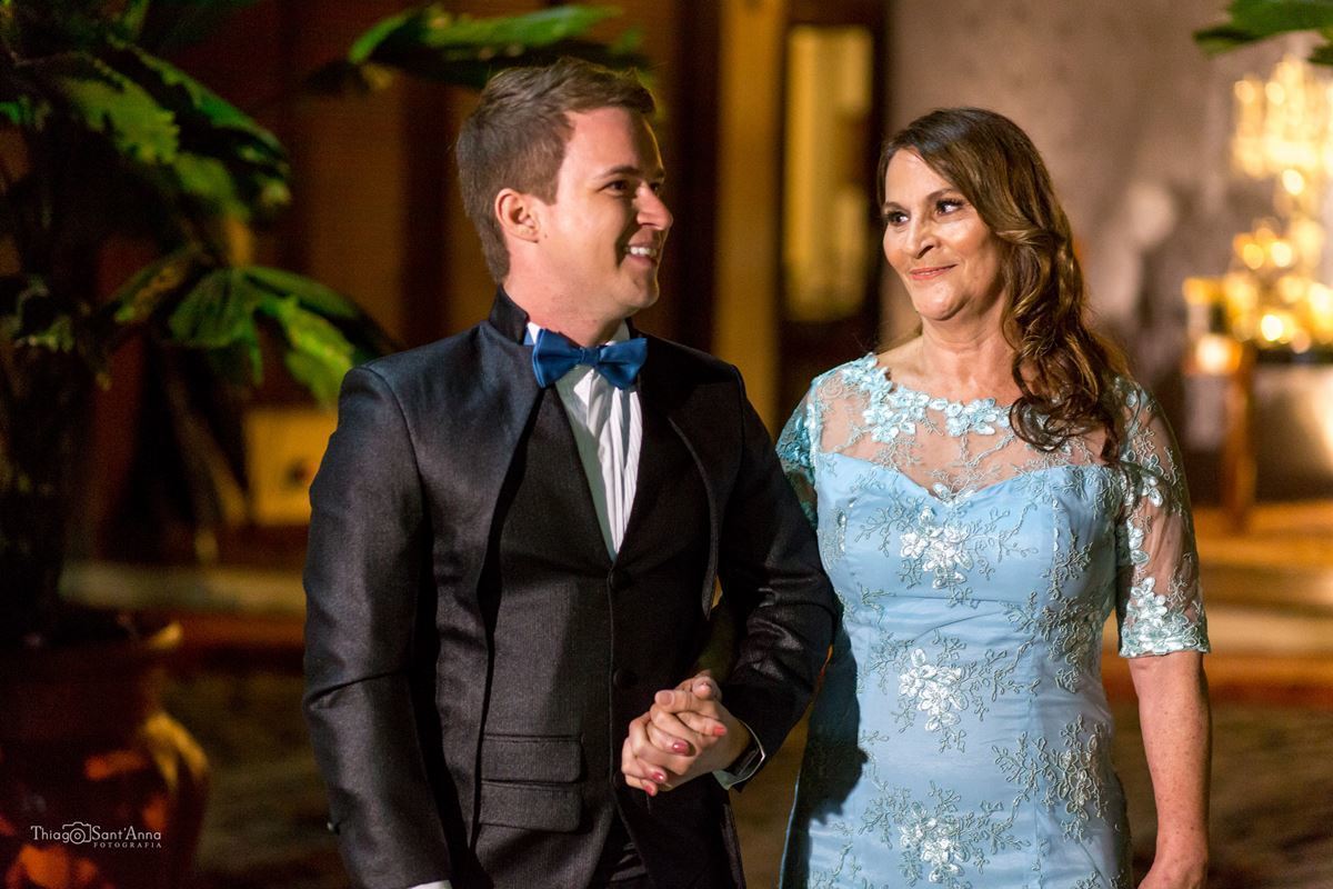 noivo gravata borboleta azul sorri de mãos dadas com sua mãe 