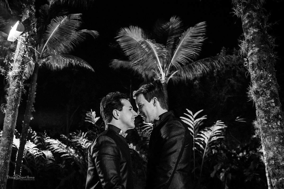 noivos posam mãos dadas rosto frente frente árvores preto e branco