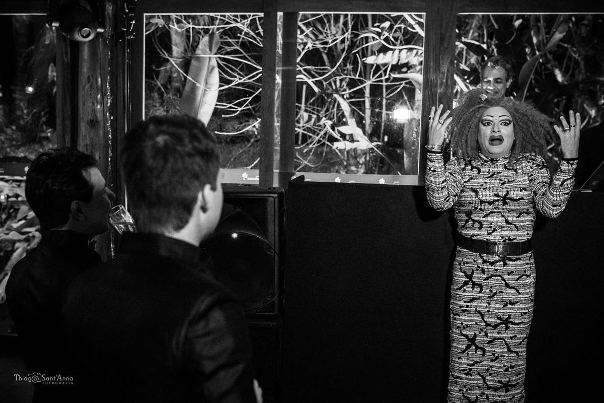 drag queen anima festa casamento noivos observam preto e branco