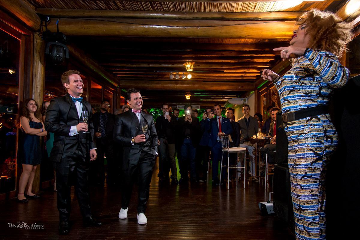 drag queen anima festa casamento noivos observam convidados ao fundo