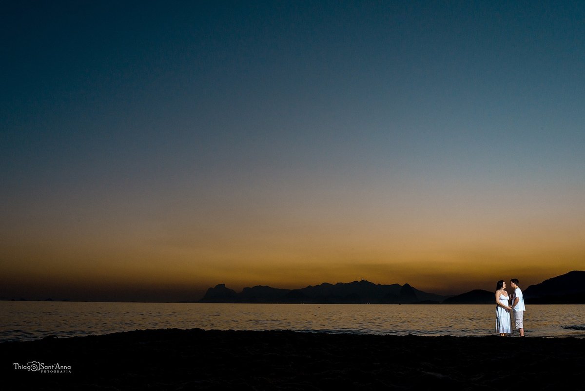 casal no contra luz do pôr do sol ao lado do horizonte em praia no Rio de Janeiro
