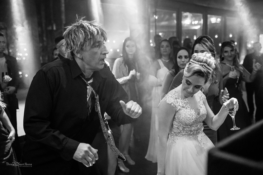 Foto em preto e branco do tio peter pan animando a pista de dança de um casamento