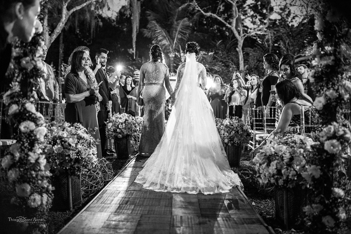 Fotografia em preto e branco da noiva entrando com a mãe