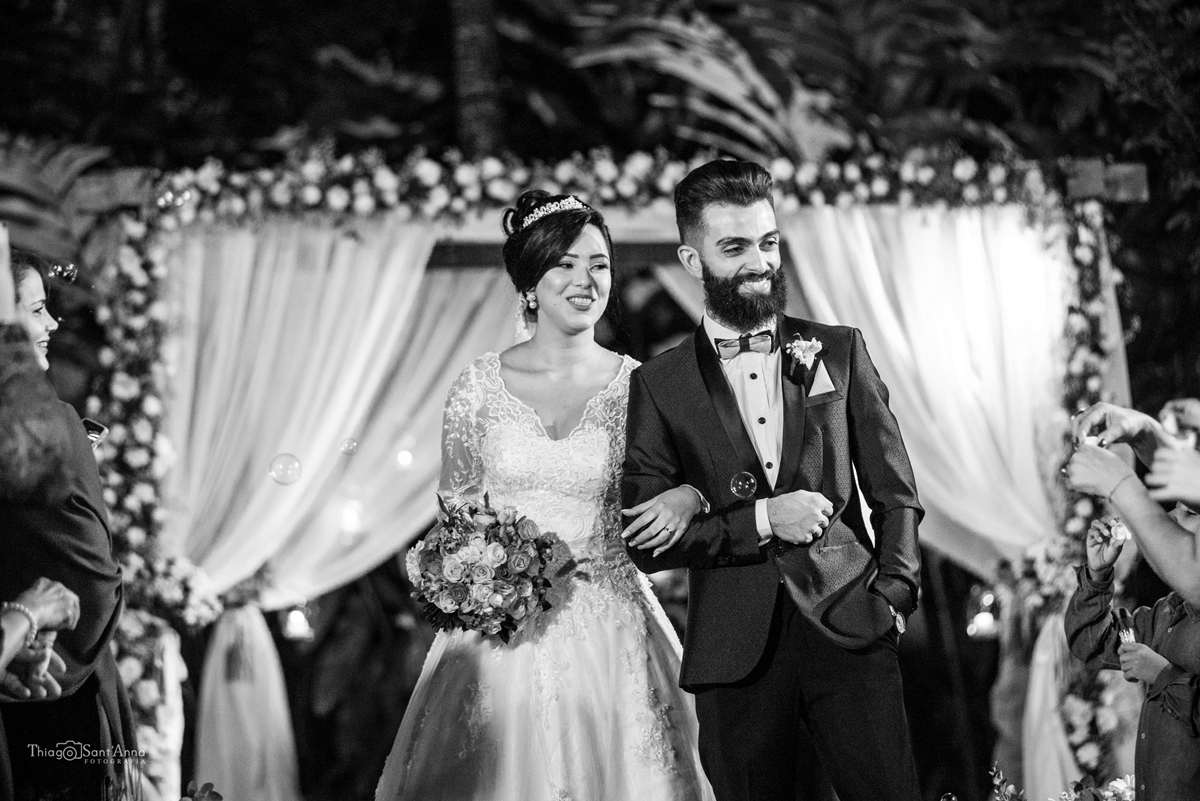 Fotografia em preto e branco da saída dos noivos do casamento