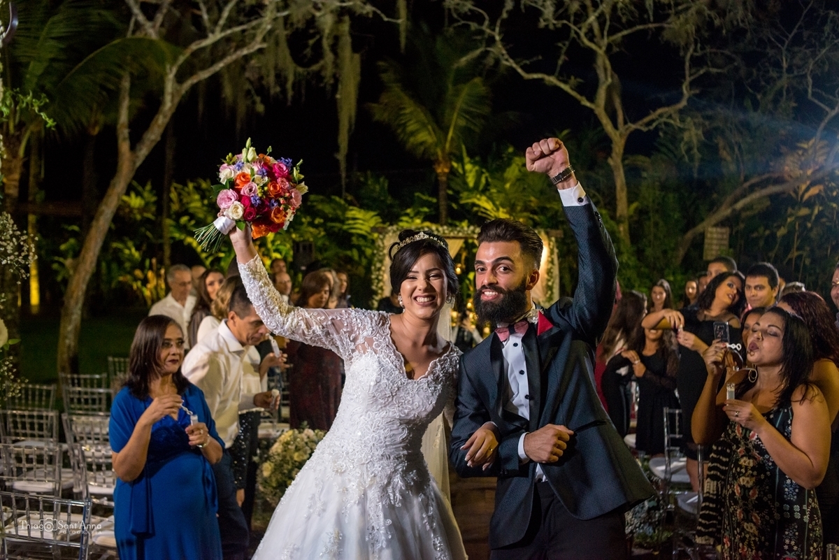 Noivos comemorando o casamento na saída da cerimônia