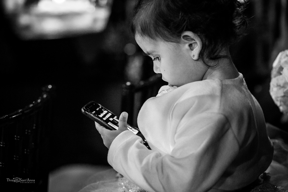 menininha mexendo no celular durante a cerimônia de casamento