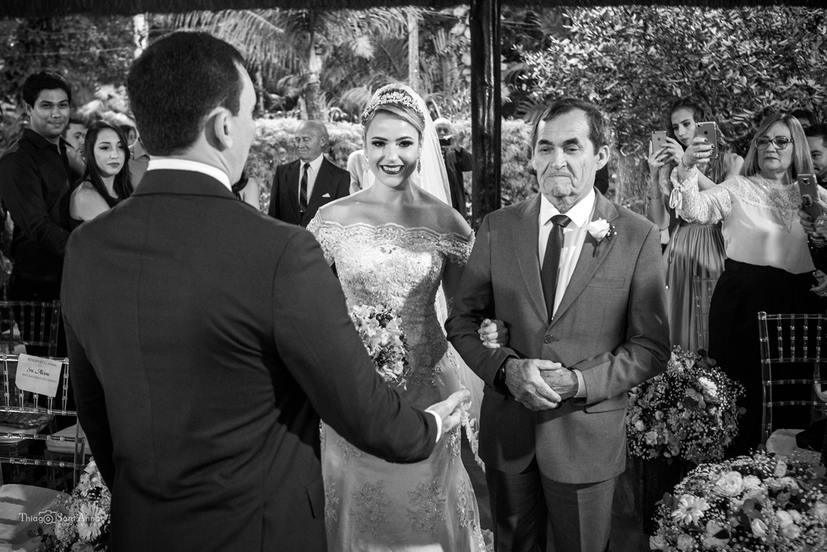 Fotografia em preto e branco da noiva chegando ao altar.
