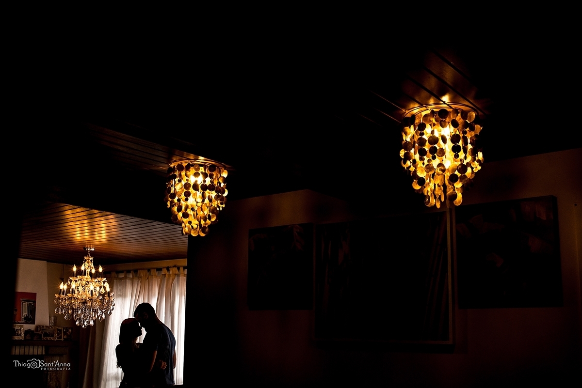 Casal no contra luz na sala de lustres